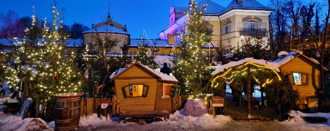 Weihnachtsmarkt bei Nacht im Winter, beleuchtet mit Lichtern.