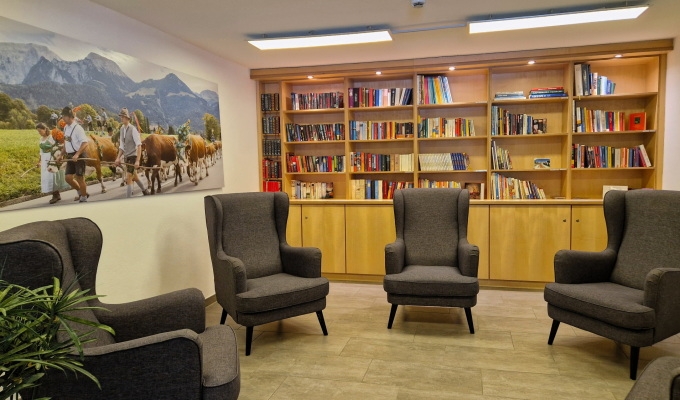 Gemütliche Bibliothek mit Tisch, Stühlen und Sofa im Haus Chiemgau – ideal zum Lesen und Entspannen.