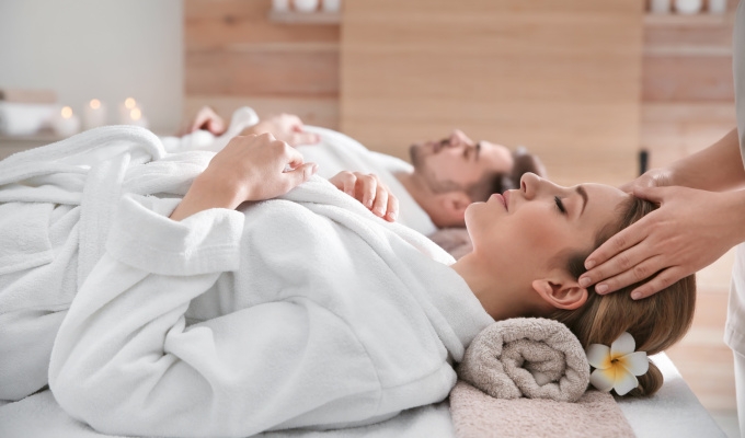 Wellnessbereich im Haus Chiemgau – Frau erhält eine Kopfmassage, beide Personen im Bademantel.