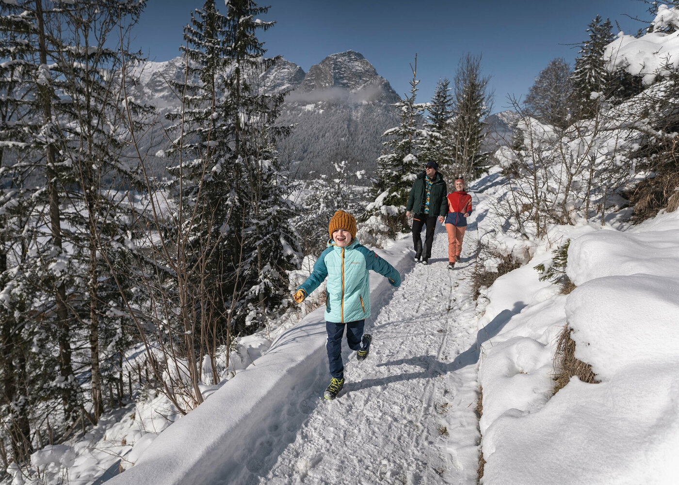 Familie beim Spazierengehen im Schnee.