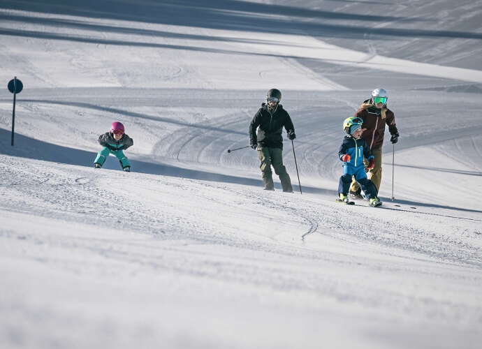 Familie beim Skifahren im Winter auf der Piste.
