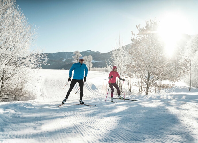 Mann und Frau beim Langlaufen im Winter.