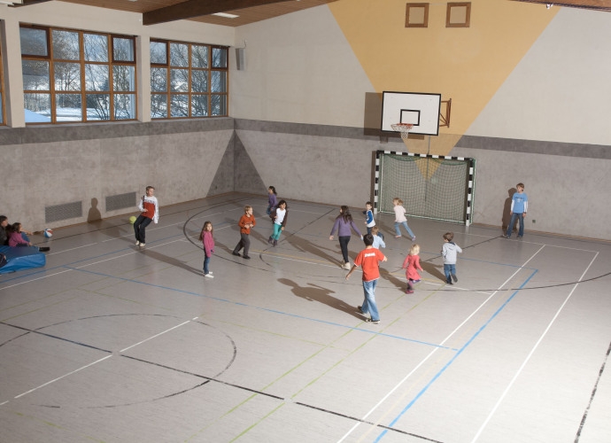 Turnhalle im Haus Chiemgau mit Kindern beim Fußballspielen.