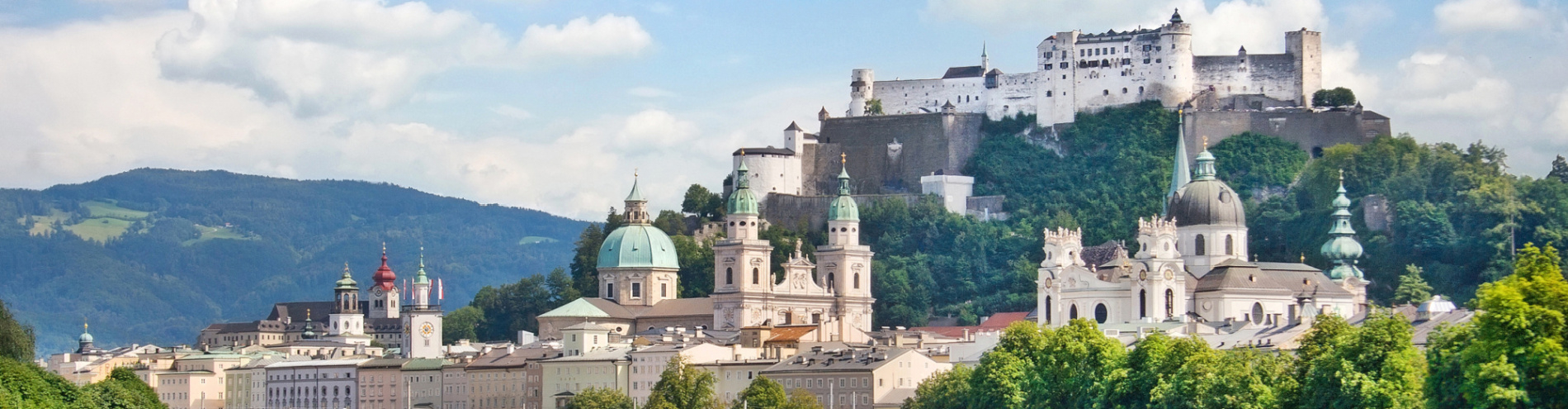 Skyline von Salzburg mit Fluss im Vordergrund.
